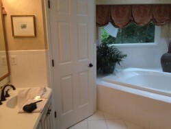 Before photo shows separate toilet room and corner bath tub.
